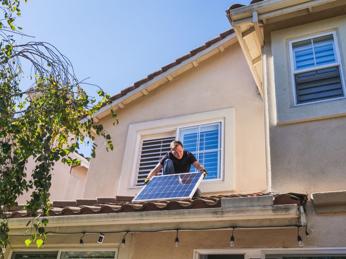Installer mounting solar panels on a roof